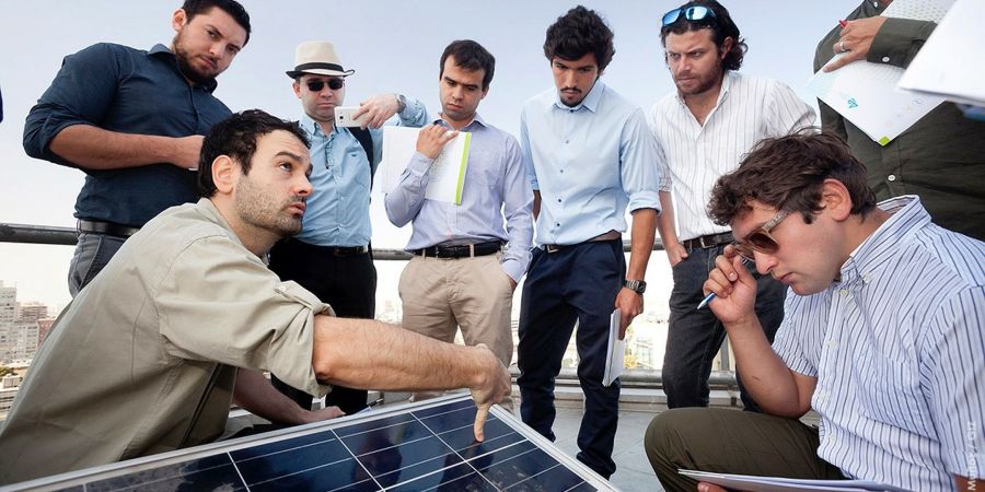 A group of renewable energy experts analysing a solar panel