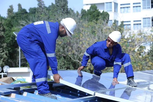 Two people installing solar PV in Tunisia
