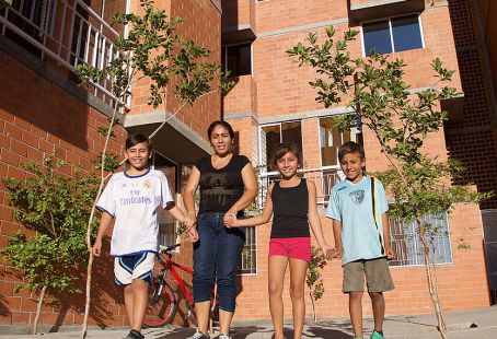 A family in front of their newly built apartment complex