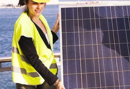 Female worker holding a solar panel