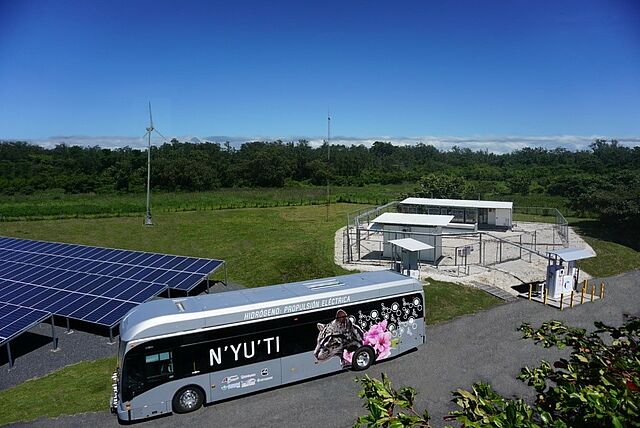 A bus parked next to a solar panel