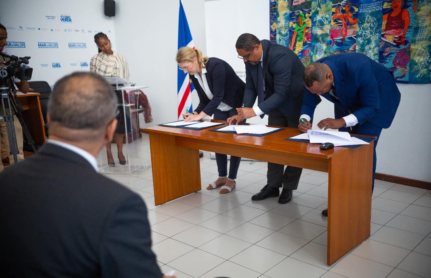 Two men and a woman are signing a contract