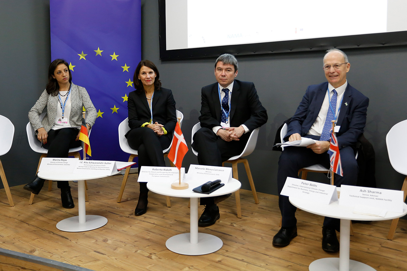 Four panelists in front of European flag